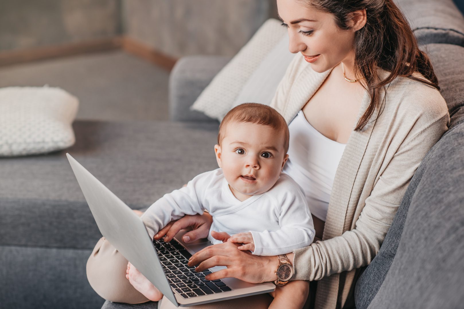 young mother using TeamViewer Remote Access to work from home and attend online meeting while taking care of baby
