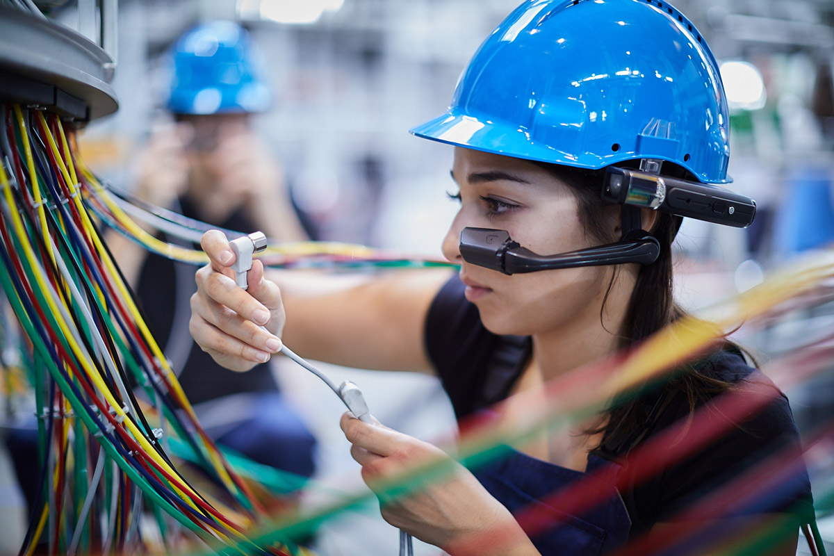 Woman-maintaining-electrics-from-bottling-machine-wearing-smart-glasses-and-safety-helmet_Copyright-TeamViewer